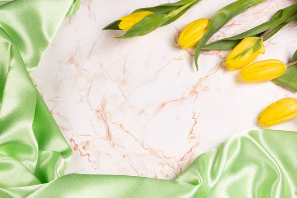 Hintergrund Mit Grünem Seidenstoff Auf Marmor Und Gelben Tulpen — Stockfoto