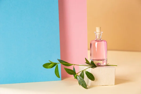 ボトルの色の幾何学的背景に香水 — ストック写真