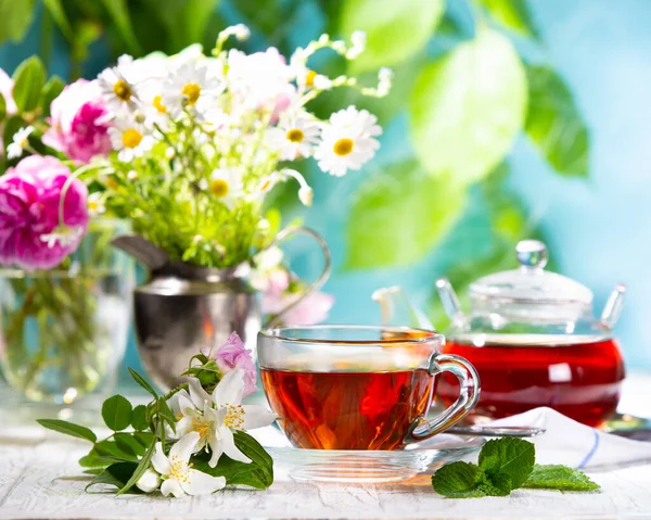 在阳光灿烂的日子里 一杯茶和一片鲜花 — 图库照片
