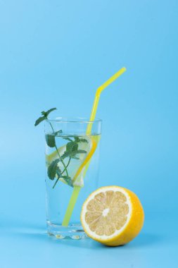 Serinletici bir içecek ve mavi arka planda meyveler.