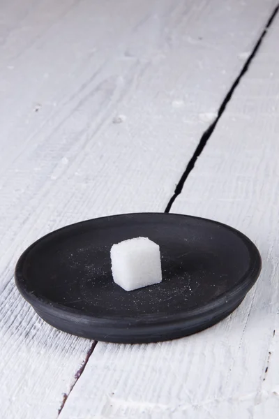Rafinovaný cukr na černý talíř — Stock fotografie