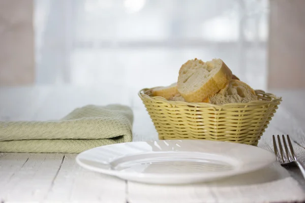 Piatto vuoto, forcella e un cesto di pane — Foto Stock