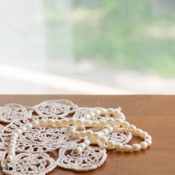 Pearl necklace on a lacy napkin — Stock Photo, Image