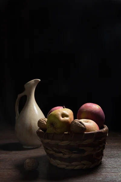 Яблоки и груши в плетеной корзине — стоковое фото