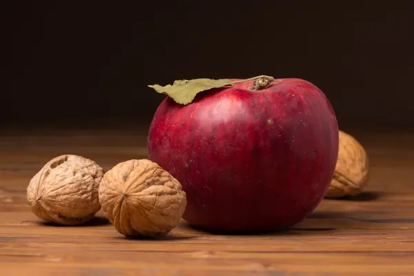 Спелые грецкие орехи и яблоко — стоковое фото
