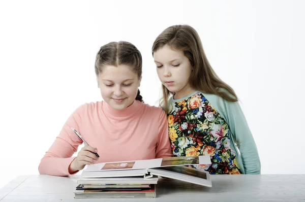 Niñas leen libros en la mesa sobre blanco Imagen De Stock