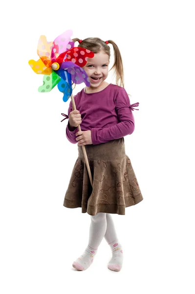 Kleines Mädchen hält bunte Windmühle isoliert — Stockfoto