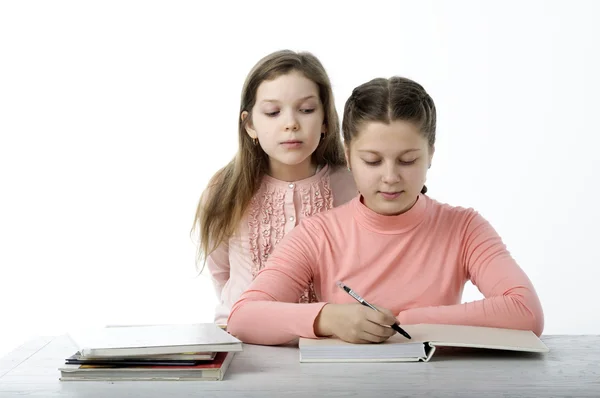 Les petites filles lisent des livres à table sur le blanc — Photo