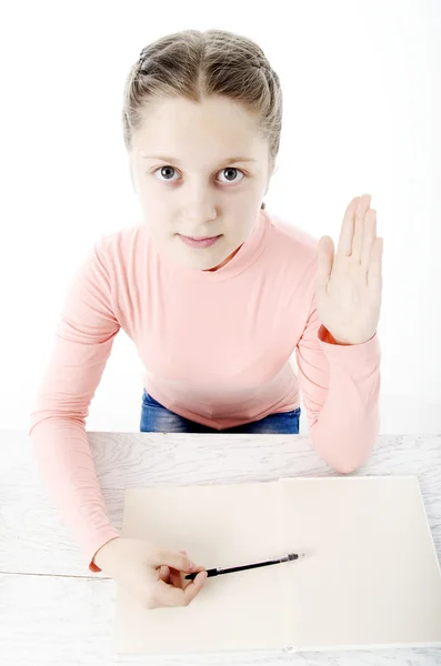 Meisje aan de tafel in school op wit — Stockfoto