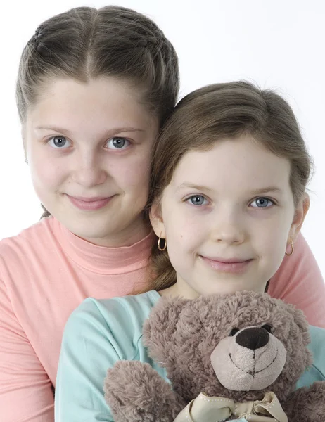 Portrait of pretty little girls holding teddy bear on white — Stock Photo, Image