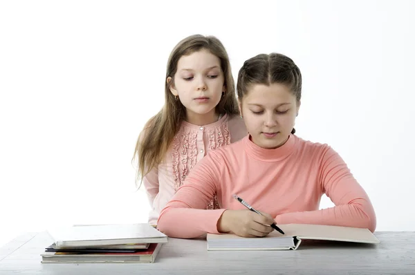 女の子は白のテーブルで本を読む ストック画像