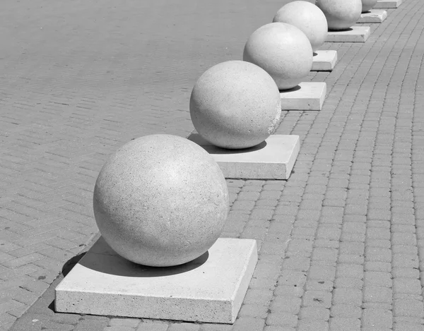 Protection in the form of decorative stone spheres on sidewalk