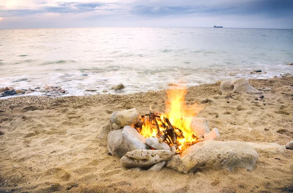 Fuego nocturno solitario en la costa — Foto de Stock