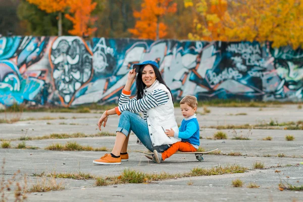 Mother and son sitting on a skateboard — Stock fotografie