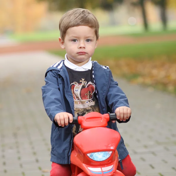 Bonito pequeno motociclista na estrada com motocicleta — Fotografia de Stock