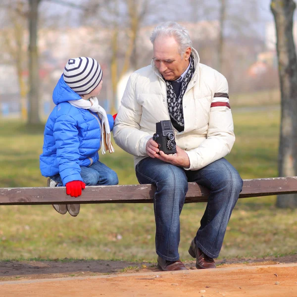 Dědeček ukazuje vnuk retro fotoaparát — Stock fotografie