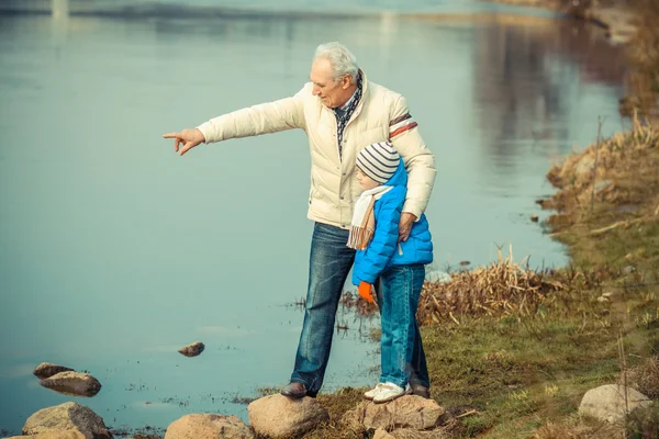 Grand-père et petit-fils près de la rivière — Photo