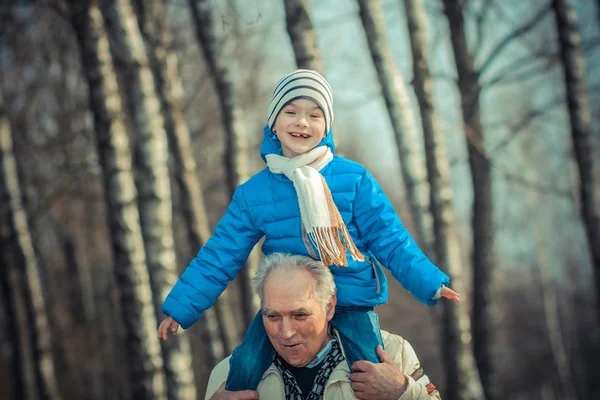 Grandfather carries grandson on his shoulders — Stock Photo, Image