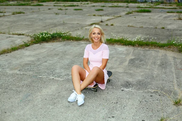Söt blond tjej med skateboard — Stockfoto