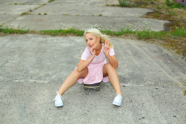 Schattige blonde meisje met skateboard — Stockfoto