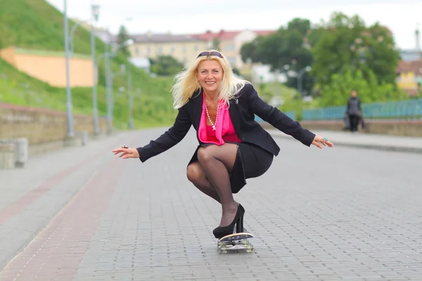 Geschäftsfrau auf einem Skateboard im Freien — Stockfoto