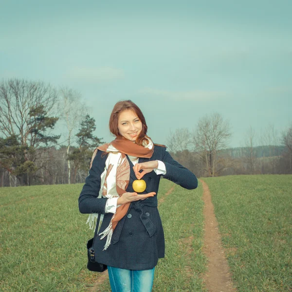 Молодая женщина с яблоком на открытом воздухе — стоковое фото