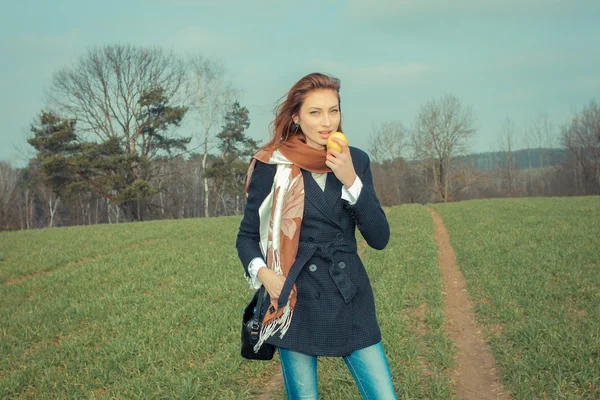 Jonge vrouw apple buitenshuis eten — Stockfoto