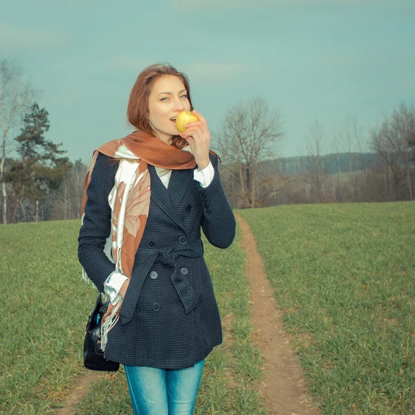 Ung kvinna äta äpple utomhus — Stockfoto