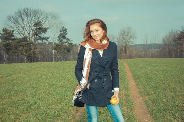Jeune femme avec pomme en plein air — Photo