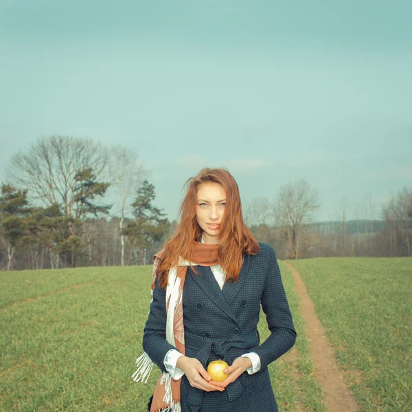 Young woman with apple outdoors — Stock Photo, Image