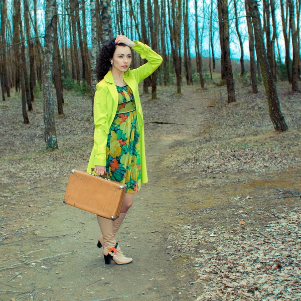 Menina com mala na estrada de campo — Fotografia de Stock