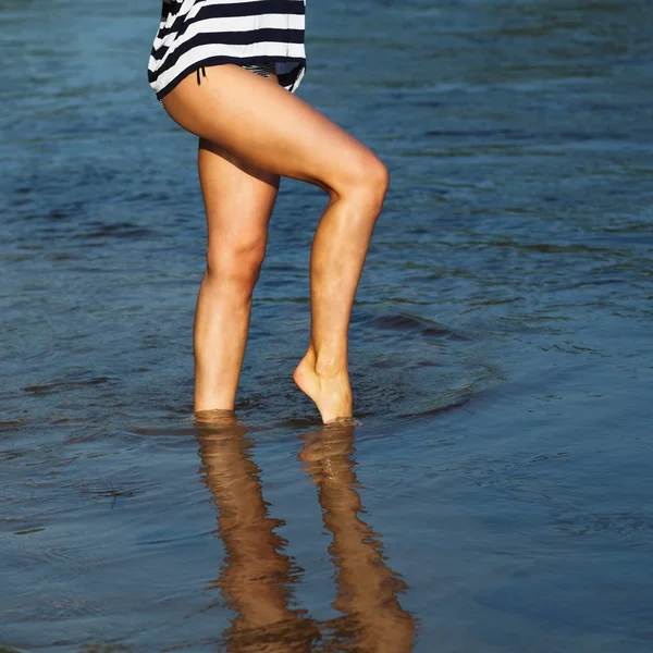 Pernas femininas andando na água — Fotografia de Stock