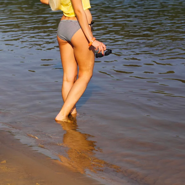 Frauenbeine laufen im Wasser — Stockfoto