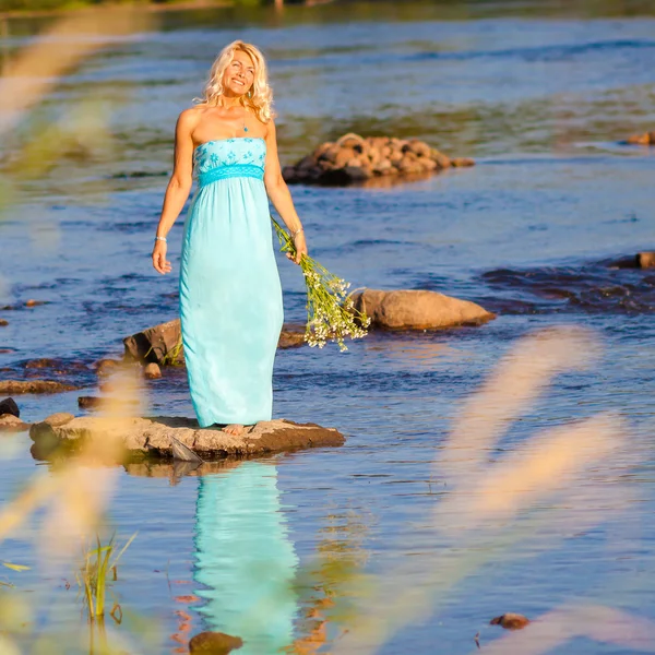 Mulher em um vestido longo na costa — Fotografia de Stock