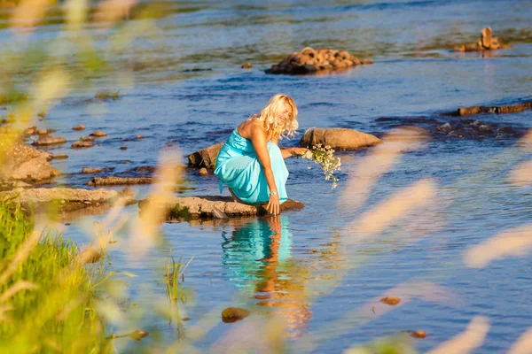 Žena v dlouhých šatech na pobřeží — Stock fotografie