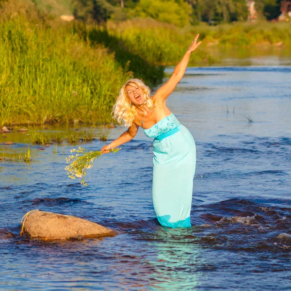 Flicka i blå klänning njuter av vattnet — Stockfoto