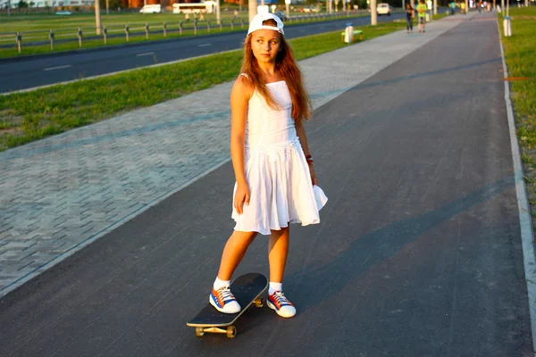 Adolescente menina com um skate — Fotografia de Stock