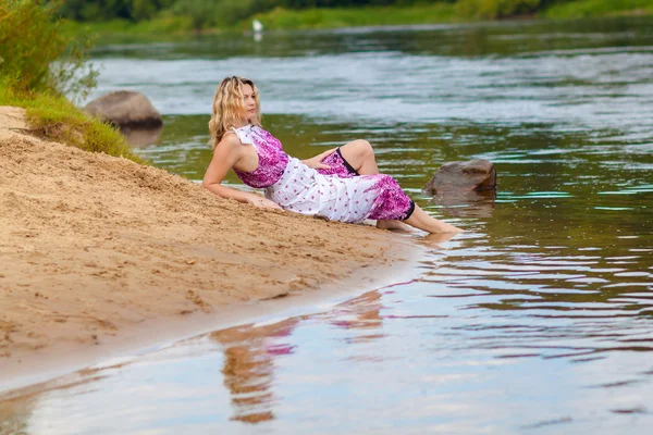 Žena v dlouhých šatech na pobřeží — Stock fotografie