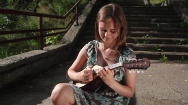 Güzel bir kız parlak bir yaz gününde kitap okur.