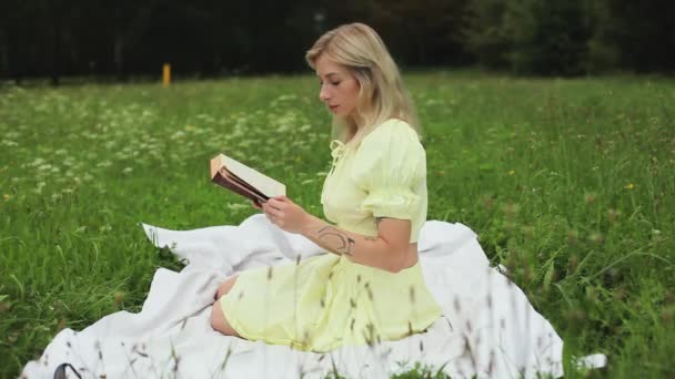 Krásná dívka čte knihu v jasný letní den — Stock video
