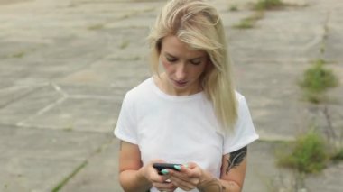 Güzel bir sarışın cep telefonuna bakıyor. Hippi bir kız kurye okur ve kötü haberleri görür. Çok üzgün.