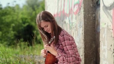 Uzun saçlı güzel duygusal bir kız müzik aleti çalıyor. Yavaş çekim 