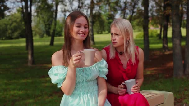 Matka a dcera popíjejí čaj v parku. — Stock video