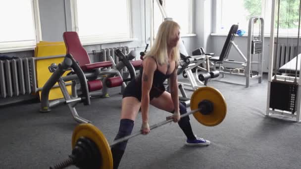 Una hermosa chica atlética se dedica al gimnasio. Barbell, punto muerto — Vídeos de Stock