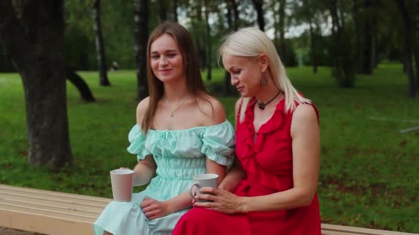 Madre e figlia stanno bevendo il tè nel parco — Video Stock
