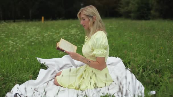Ένα Όμορφο Κορίτσι Διαβάζει Ένα Βιβλίο Για Μια Φωτεινή Καλοκαιρινή — Αρχείο Βίντεο