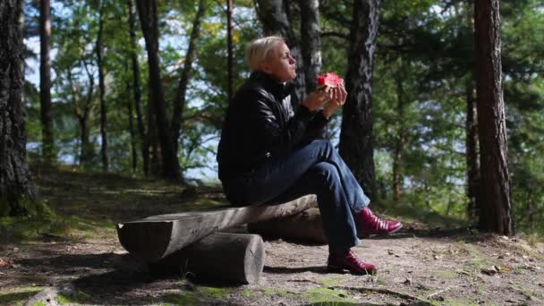 Pensiv medelålders kvinna äter vattenmelon utomhus — Stockvideo