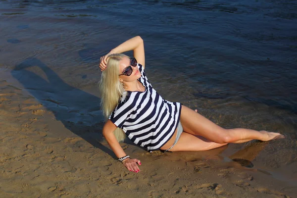 Mooie blonde in een striped blouse op strand — Stockfoto
