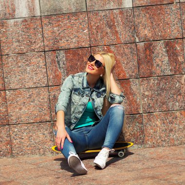 ceketli bir kaykay üzerinde oturan kız