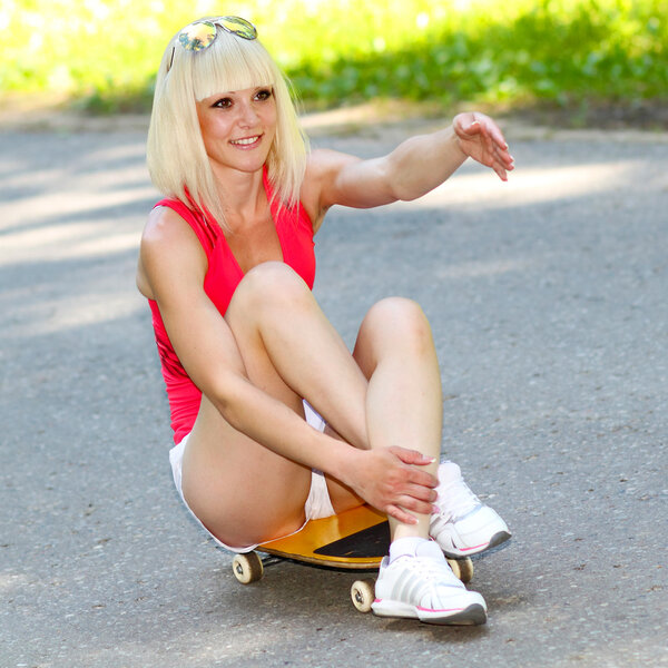 Girl rides sitting on skateboard